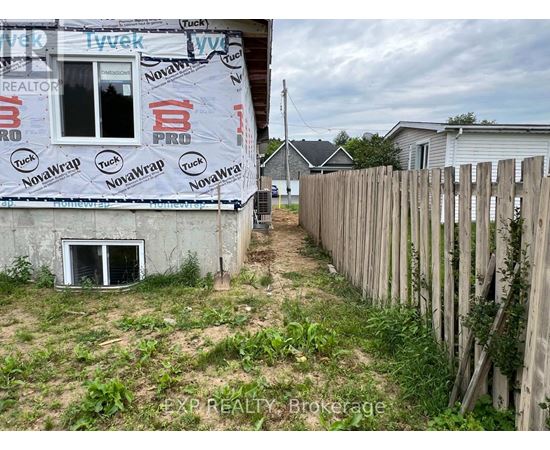 A house under construction with a NovaWrap insulation advertisement on the wall.