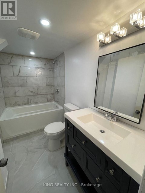 A bathroom with a marble wall and a white toilet.