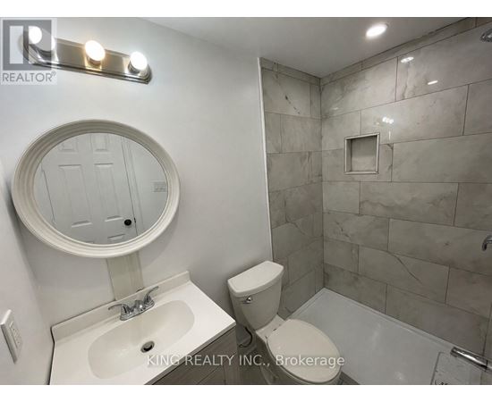 A bathroom with a sink, toilet, and a shower.