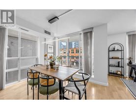 A dining room with a table and chairs and a view of the city.