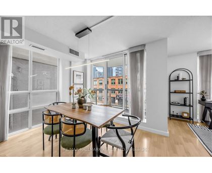 A dining room with a table and chairs and a view of the city.
