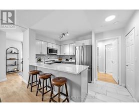A modern kitchen with white cabinets and a bar area.