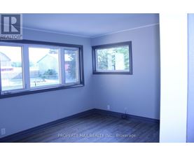 A room with a window and a wooden floor.