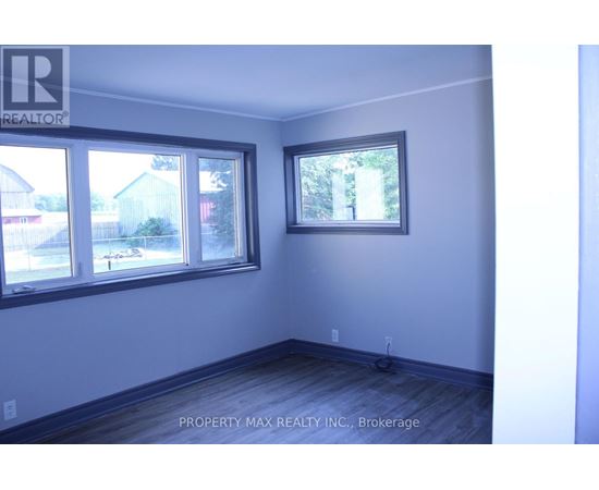 A room with a window and a wooden floor.