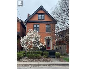 A red brick house with a white flowering tree in front.