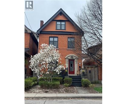 A red brick house with a white flowering tree in front.