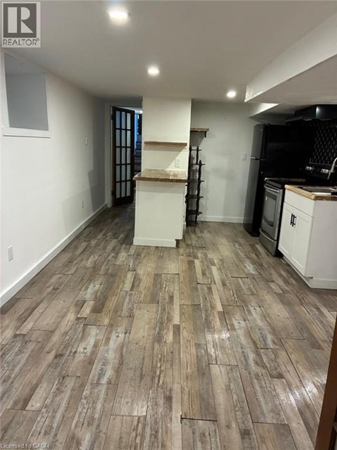 A kitchen with a wooden floor and white walls.