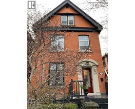 A red brick house with a black roof and a white door.