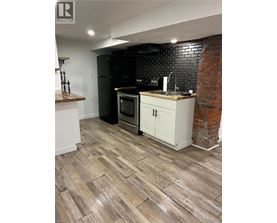 A kitchen with a black fridge and white cabinets.