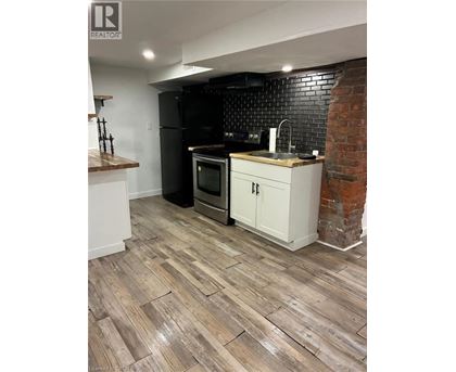 A kitchen with a black fridge and white cabinets.