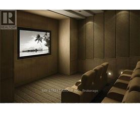 A home theater room with a large screen and multiple recliner seats.