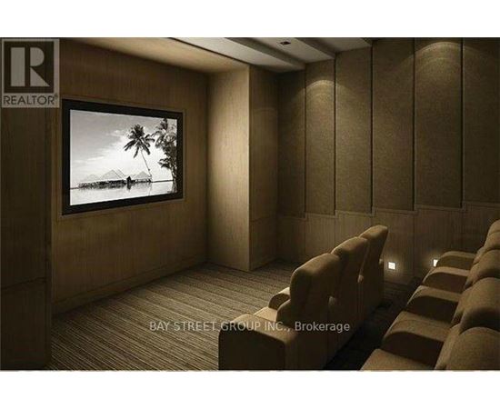 A home theater room with a large screen and multiple recliner seats.