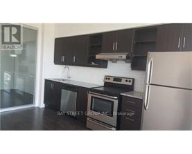 A kitchen with black cabinets and stainless steel appliances.