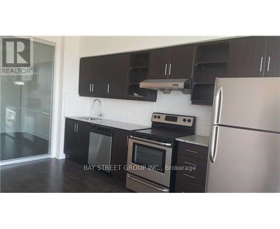 A kitchen with black cabinets and stainless steel appliances.