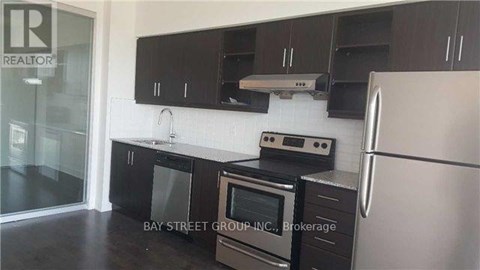 A kitchen with black cabinets and stainless steel appliances.