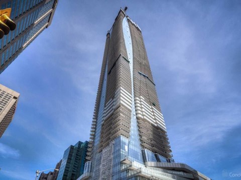 A tall skyscraper with a glass facade stands in a cityscape.