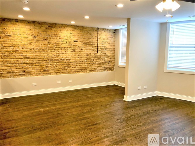 A room with a brick wall and wooden flooring.