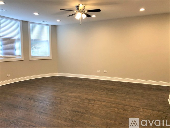 A room with a ceiling fan and wooden flooring.