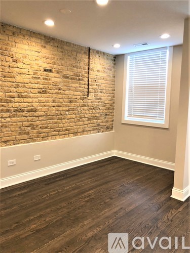 A room with a brick wall and wooden flooring.
