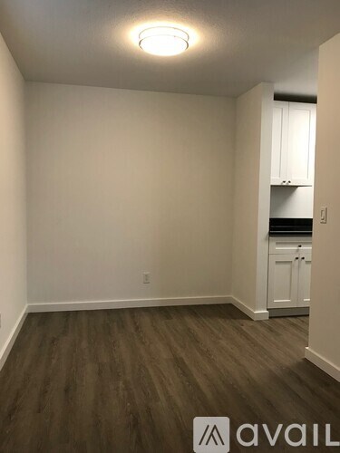 A room with wooden flooring and white walls.