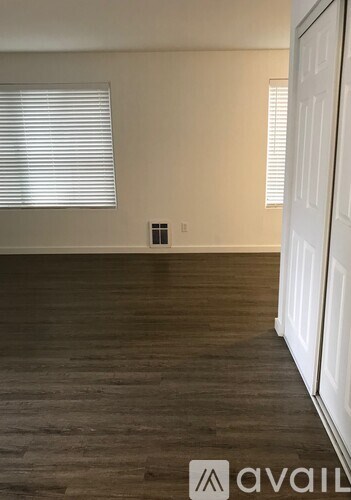 A room with wooden flooring and a white door.