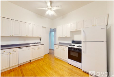 A kitchen with white cabinets and a white refrigerator.