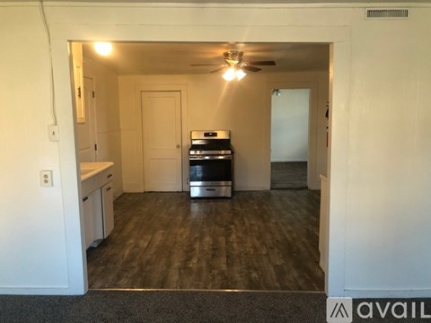 A kitchen with a stove top oven and a fan.