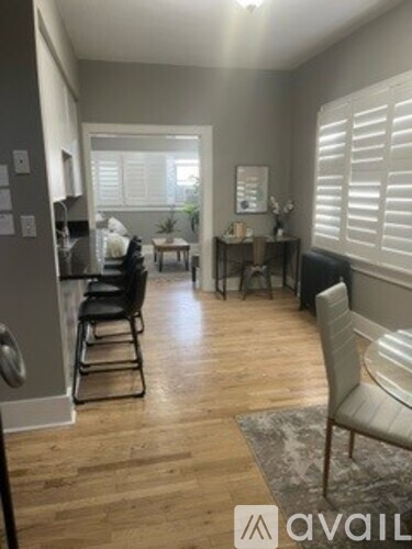 A living room with a black chair and a grey couch.