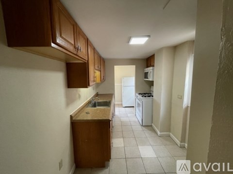A kitchen with brown cabinets and a white dishwasher.