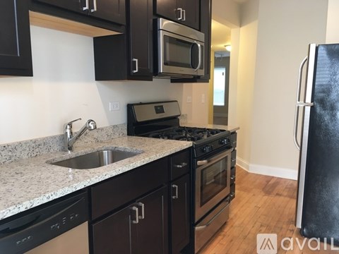 A kitchen with black cabinets and a granite countertop.
