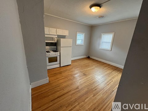 A kitchen with wooden floors and white appliances.