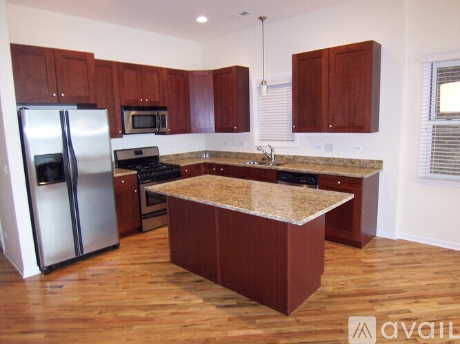 A kitchen with wooden cabinets and a granite countertop.