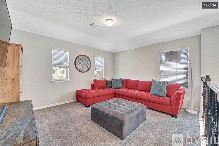 A living room with a red couch and a wooden coffee table.