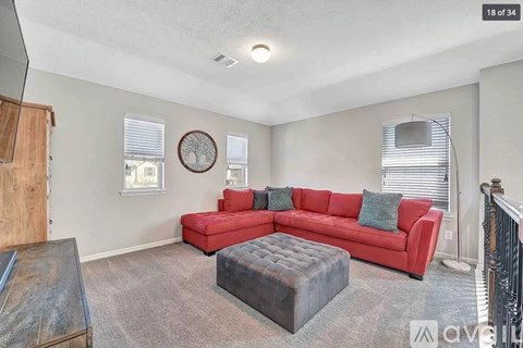 A living room with a red couch and a wooden coffee table.