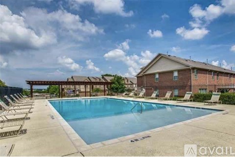 A swimming pool with lounge chairs and a building in the background.