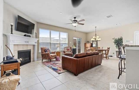 A living room with a fireplace and a flat screen TV mounted on the wall.