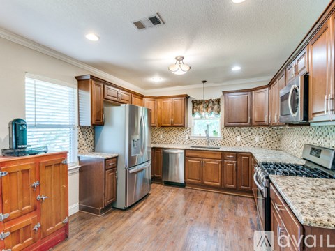 A kitchen with wooden cabinets and a granite counter top.