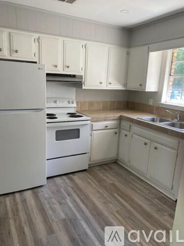 A kitchen with white appliances and cabinets.