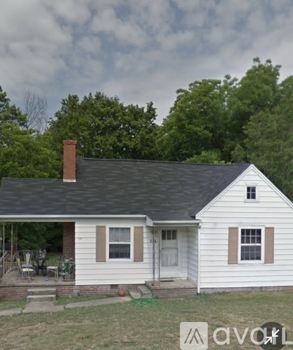 A small white house with a brown door and a brown window.