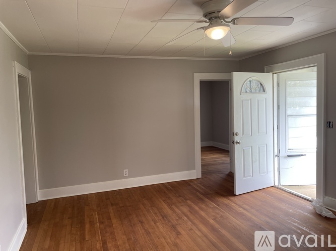 A room with wooden floors and a ceiling fan.