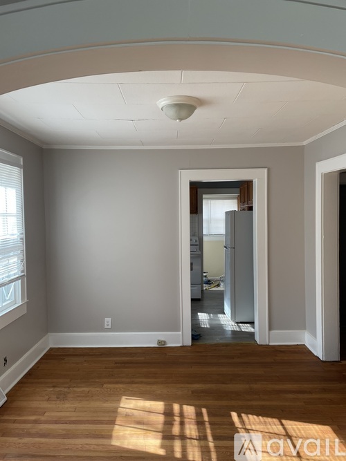 A room with wooden floors and a white ceiling with a light fixture.