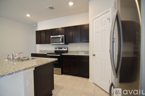 A kitchen with brown cabinets and a white door.