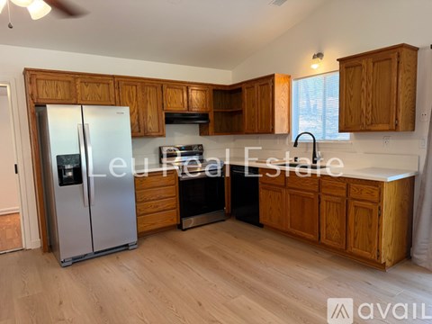 A kitchen with wooden cabinets and a stainless steel refrigerator.