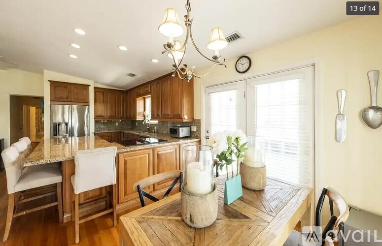 A kitchen with wooden cabinets and a marble countertop.