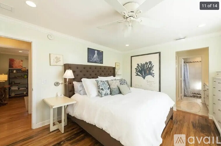 A bedroom with a large bed and a ceiling fan.