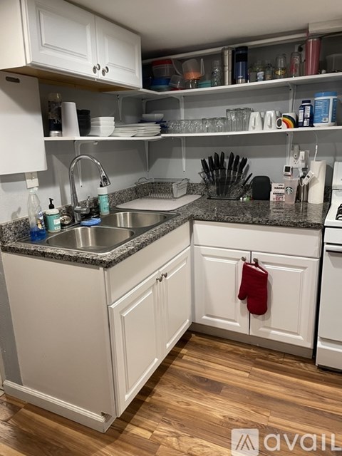 A kitchen with white cabinets and a granite countertop.