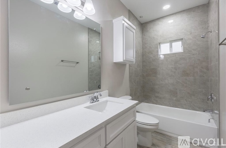 A bathroom with a white countertop and a white toilet.