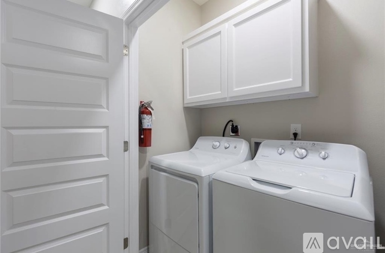 A white bathroom with a washer and dryer.