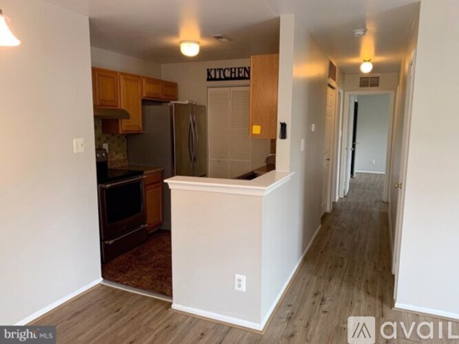 A kitchen area with wooden cabinets and a refrigerator.