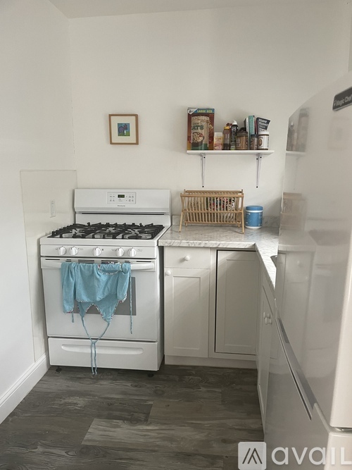 A kitchen with a white stove and a white fridge.
